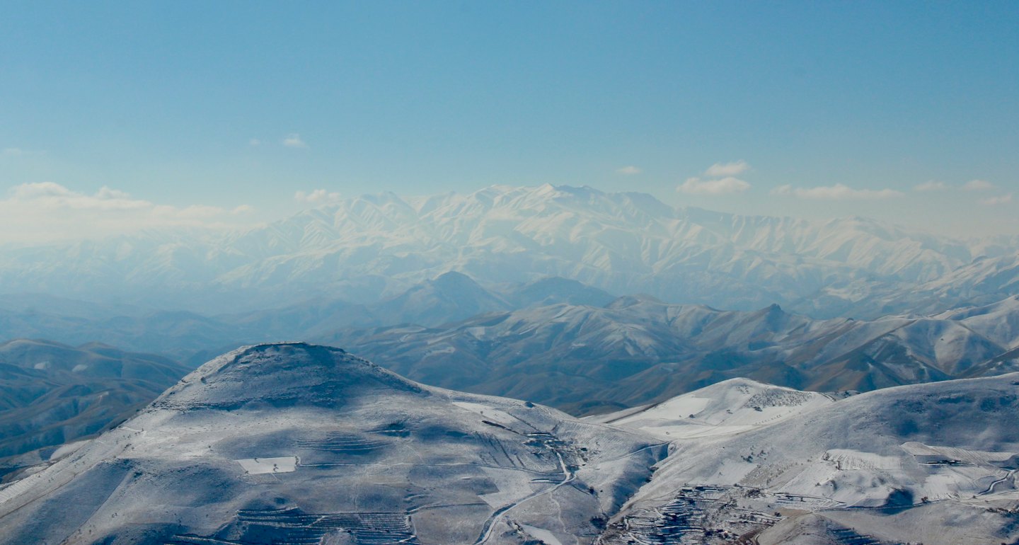 Snow-covered mountain peaks stretch into a hazy distance.
